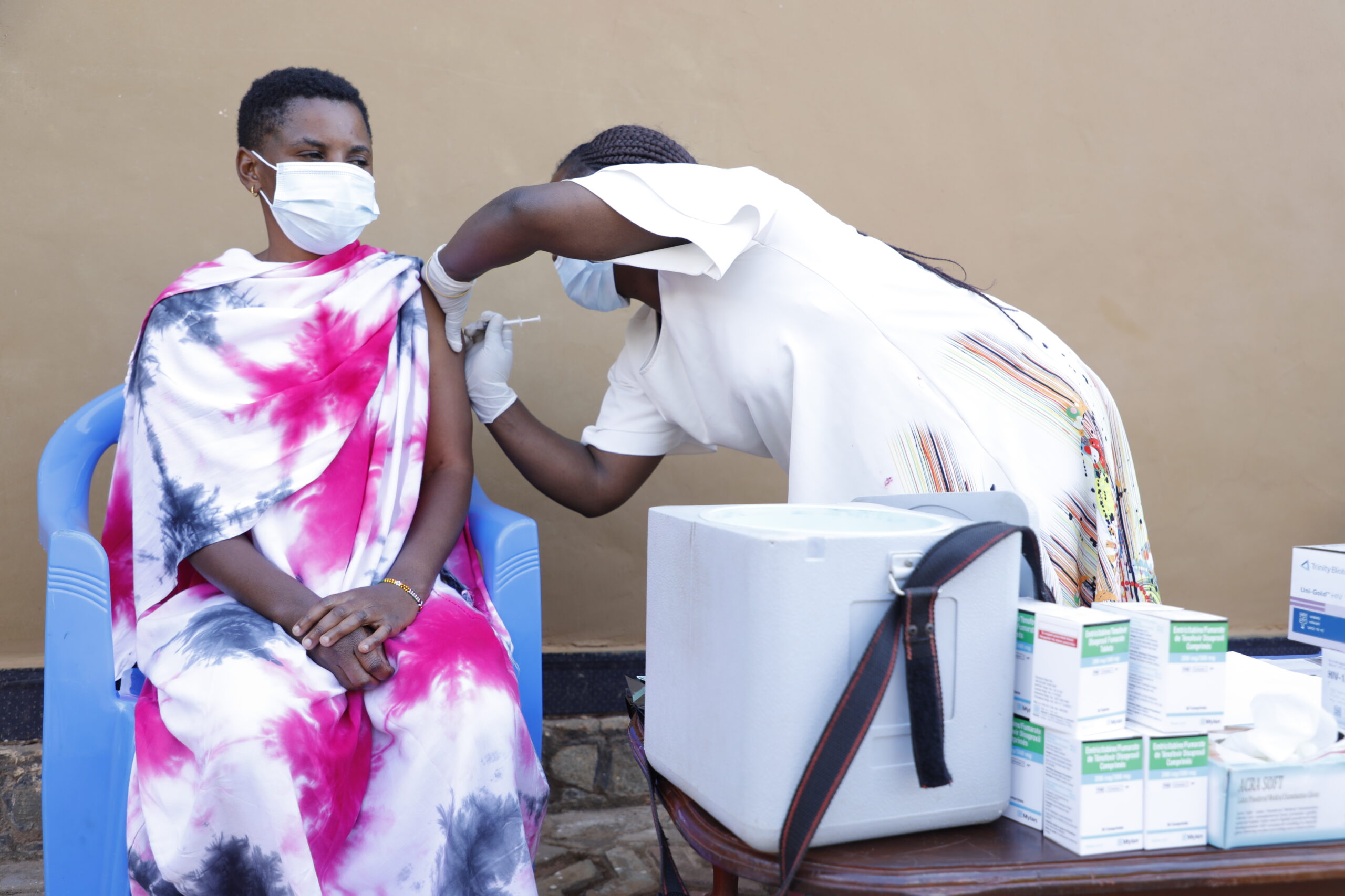 A health care worker trained by the EpiC project administers a COVID-19 vaccine to a female sex worker. Photo by Agness John.